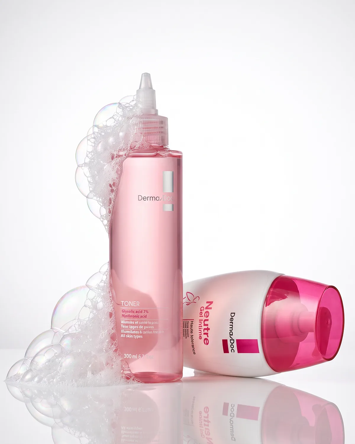 Toner et Gel Intime Neutre DermaDoc au milieu de la mousse, sur fond clair.